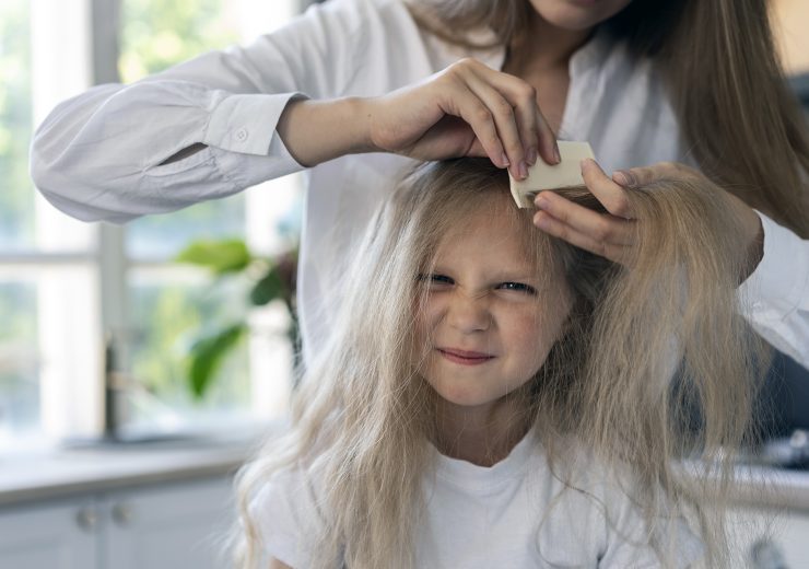 front-view-woman-helping-girl-with-lices