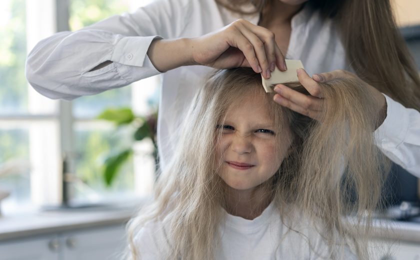 front-view-woman-helping-girl-with-lices
